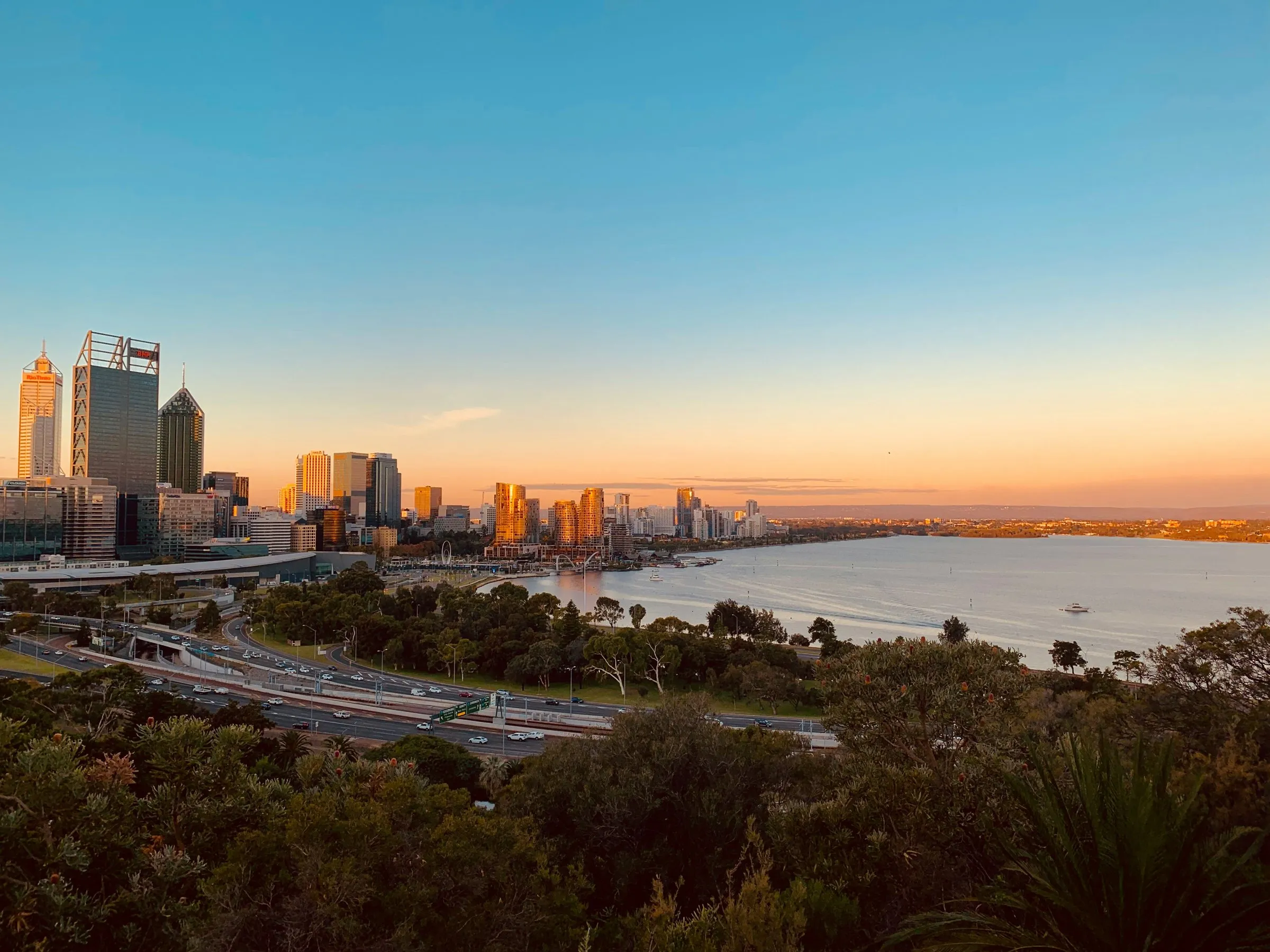 A city skyline across the river at sunset